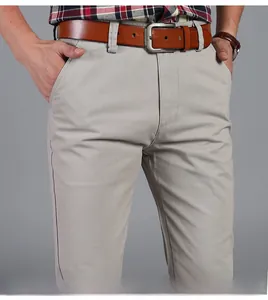 Close-up of men's beige casual trousers with brown leather belt and cotton twill texture