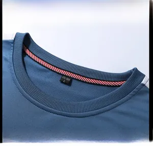 Detailed close-up of blue crew neck sweatshirt with ribbed collar and size tag