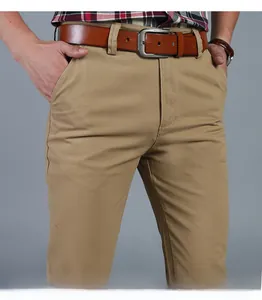 Detail of khaki men's business casual trousers with a brown leather belt and metal buckle