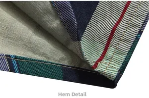 Detailed close-up of the shirt hem showcasing the classic plaid pattern and sewing craftsmanship