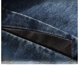 Dettaglio di un blazer in cotone blu con elegante bordo in pelle sulla tasca laterale