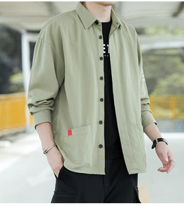 Detail of light olive cotton work shirt featuring flap pockets and buttoned cuffs