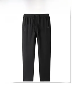 Detail view of men's black cotton sports trousers featuring drawstring waist and logo