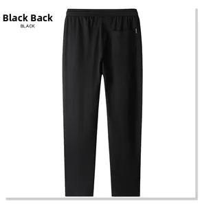 Detail of black cotton jogger pants featuring an elastic waist and back pocket with red tag