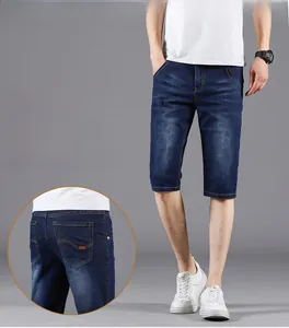 Detail view of denim shorts featuring deep blue wash texture and reinforced back pocket stitching
