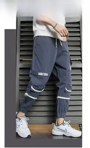 Dettaglio dei pantaloni cargo da uomo con ampie tasche laterali e coulisse in vita