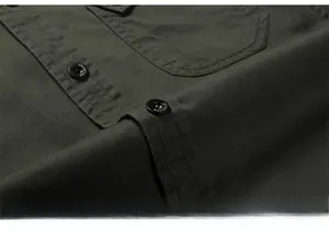 Close-up of military green cotton shirt showing canvas texture and cargo pocket detail