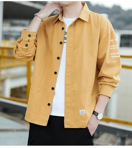 Close-up of mustard yellow cotton work shirt featuring double square pockets and letter prints
