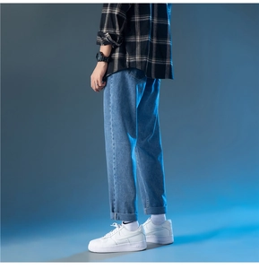 Détail du jean droit bleu clair avec ourlets repliés pour un style décontracté homme