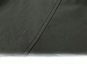 Detailed close-up of stitching on olive green heavy fabric with brushed texture
