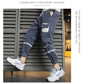 Dettaglio dei pantaloni cargo grigio scuro da uomo con tasche laterali beige funzionali
