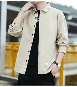 Detail of khaki cotton work shirt showing chest pocket label and white sleeve printing