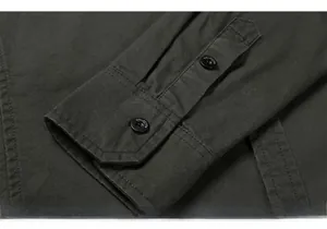Detail of olive green shirt cuff with reinforced double stitching and logo buttons