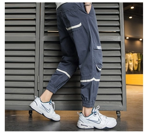 Dettaglio dei pantaloni cargo blu scuro con grandi tasche laterali e polsini elastici
