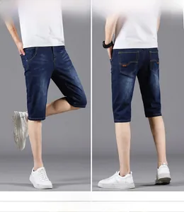 Detailed views of men's dark blue denim shorts with five pockets and leather patch
