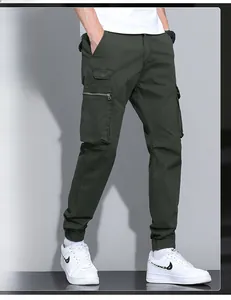 Detailed view of olive cargo pants featuring multi-pocket design and metal zipper accents