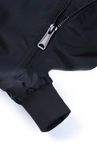 Close-up of smooth metal zipper and elastic ribbed cuff on black pilot jacket