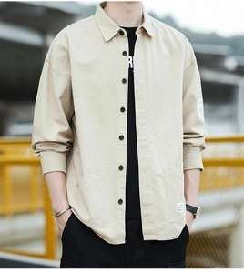 Detail of khaki cotton work shirt showing woven label and pocket stitching textures