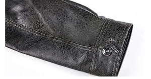Detailed close-up of distressed PU leather jacket cuff with silver metal snap button
