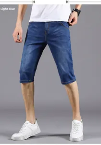 Detail of light blue denim capri pants for men with washed whiskers and slim fit cut