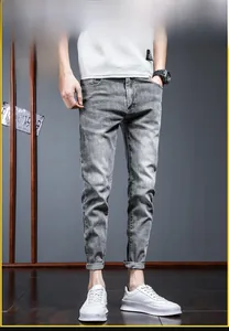 Detail of slim fit men's grey denim jeans with washed texture and tapered leg cut