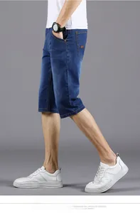 Detail view of deep blue denim shorts showing straight cut and washed fabric texture