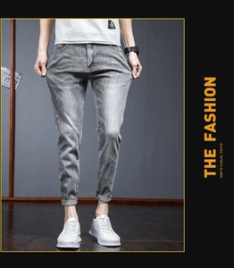 Detailed close-up of slim fit light gray snow wash denim jeans with rolled cuffs for men