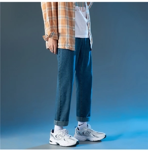 Détail de profil d'un jean bleu pour homme à coupe droite avec ourlet retroussé style décontracté