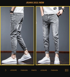 Detail of slim fit light grey washed jeans for men featuring a narrow tapered leg opening