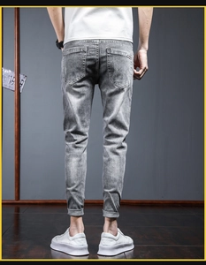 Detailed back view of slim fit grey denim jeans featuring subtle faded wash and rear pockets