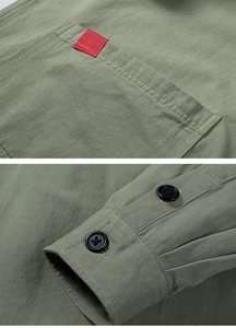 Detailed view of cargo shirt chest pocket with red tape and double button cuffs