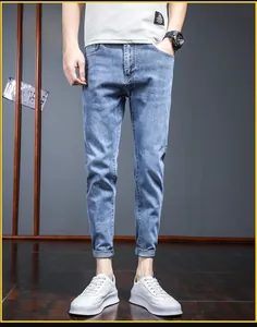 Detailed view of light blue slim fit jeans with washed finish and folded hem details