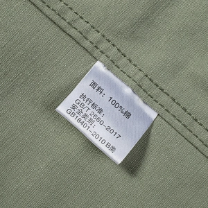 Detailed macro view of 100% cotton fabric texture and wash label on bean green shirt