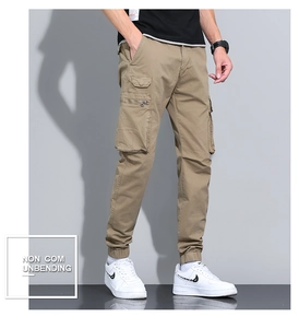 Detail of khaki cargo pants featuring large flap pockets and metal zipper accents