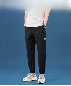 Detail view of black cargo jogger pants featuring side flap pockets and elastic cuffs