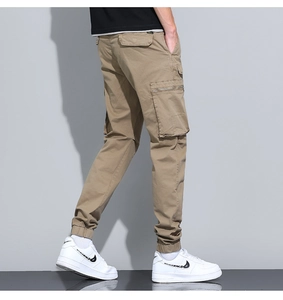 Detail of khaki cargo pants with zipper flap pocket and ribbed ankle cuffs