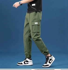 Detail view of olive green cargo pants with large side pockets and elastic waistband