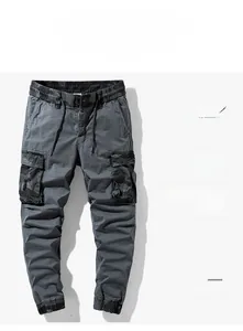 Detail of grey cargo pants with camouflage patchwork pockets and elastic drawstring waist