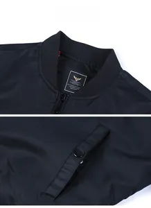Detail view of black bomber jacket featuring ribbed collar, metal zipper, and buttoned pocket