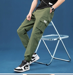 Detail of military green cargo pants featuring large side pockets and ribbed cuffs
