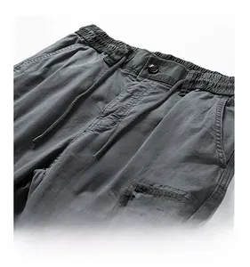 Detail of men's cargo pants showing elastic drawstring waist and premium button closure