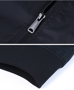 Detail of the metal zipper and elastic ribbed cuff on a black polyester flight jacket