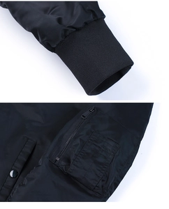 Detail of black bomber jacket featuring ribbed cuffs and a functional zippered arm pocket