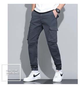 Detail of cargo pants showing side utility pockets and reinforced stitching on blue fabric