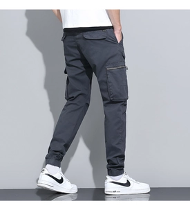 Detail view of dark grey cargo joggers with side flap pockets and metal zippers