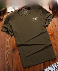 Close-up of military green t-shirt with gold wing logo and army themed print details
