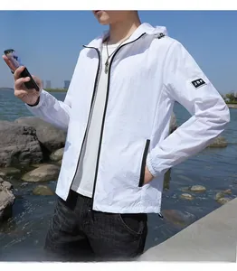 Détail de la veste anti-UV blanche avec fermeture éclair noire et broderie JSF sur la manche