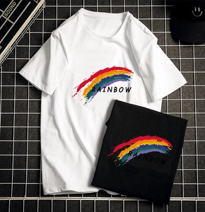 Detail of white and black cotton t-shirts featuring a colorful rainbow print and slogan