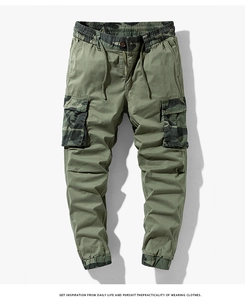 Detail of olive green cargo pants featuring camouflage pocket flaps and drawstring cuff