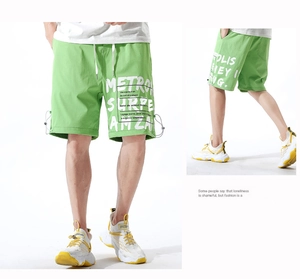 Détail du short cargo vert avec imprimés graphiques blancs et cordons de serrage